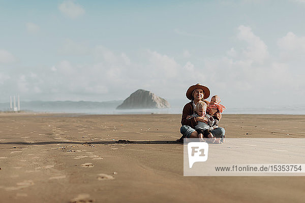 Mutter und Kinder am Strand sitzend  Morro Bay  Kalifornien  Vereinigte Staaten