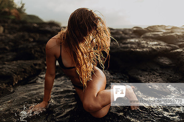 Frau posiert auf Felsen am Meer,  Princeville,  Hawaii,  USA