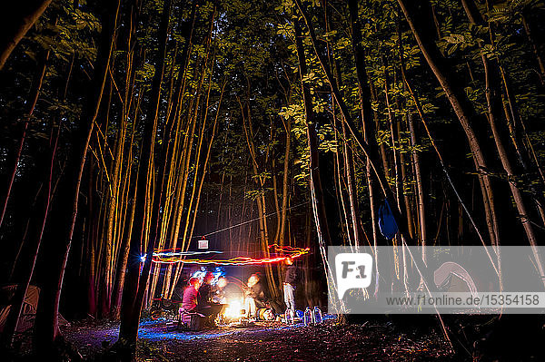 Freunde spielen mit Lichtern in einem nächtlichen Wald; Meopham  Kent  England