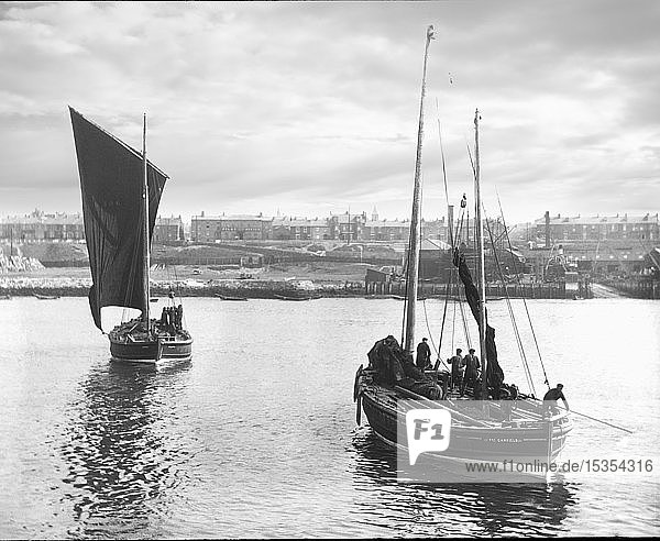 Diapositiv mit Laterna Magica um 1880  viktorianische/edwardianische Sozialgeschichte. Zwei Fischerboote verlassen den Hafen mit der Stadt South Shields im Hintergrund. Zu sehen sind Fischer auf ihren Segelfischerbooten  die sich auf das Meer vorbereiten; South Shields  Tyne and Wear  England