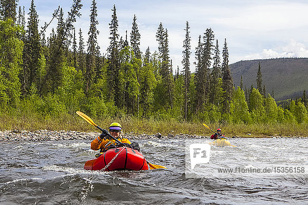 Two women packrafters negotiating a tributary of the Charley River in summertime  Yukonâ€“Charley Rivers National Preserve; Alaska  United States of America