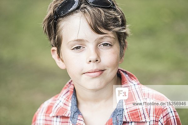 Junge  10 Jahre alt  mit Sonnenbrille und kariertem Hemd schaut cool in die Kamera  Portrait  Deutschland  Europa