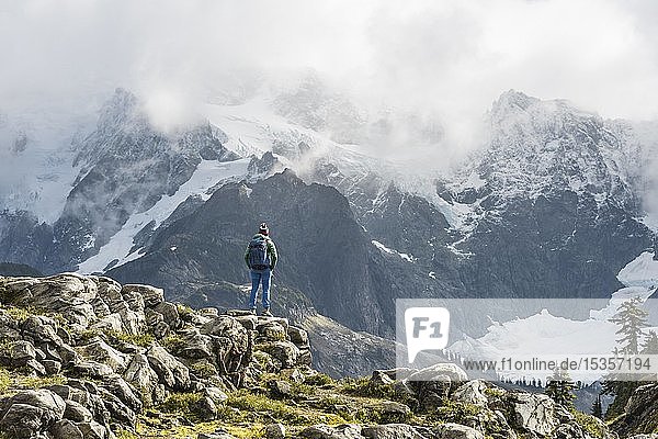 Female hiker with view of Mt. Shuksan with snow and glacier  cloudy sky  Mt. Baker-Snoqualmie National Forest  Washington  USA  North America
