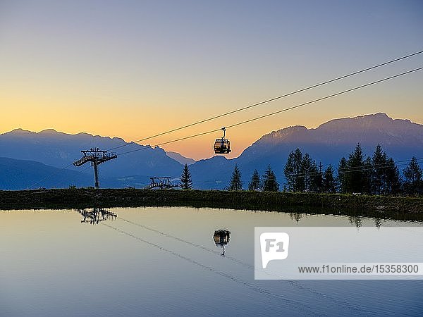 Alpenpanorama Gondel der Seilbahn Jennerbahn spiegelt sich im Abendlicht in einem künstlichen Bergsee Jenner Berchtesgadener Alpen Schönau am Königssee Berchtesgadener Land Oberbayern Bayern Deutschland Europa