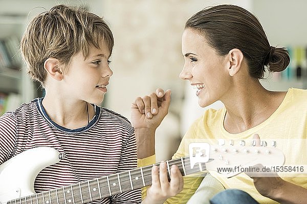 Mutter und Sohn musizieren zusammen  beide singen und Sohn spielt Gitarre  Nahaufnahme  beide schauen sich an  Deutschland  Europa
