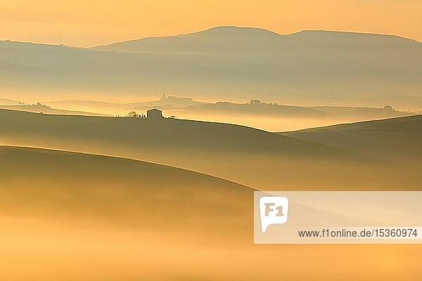 Morgenstimmung in der Toskana Hügellandschaft mit Nebel glühen in ersten Licht bei Sonnenaufgang Val d'Orcia Toskana Italien Europa