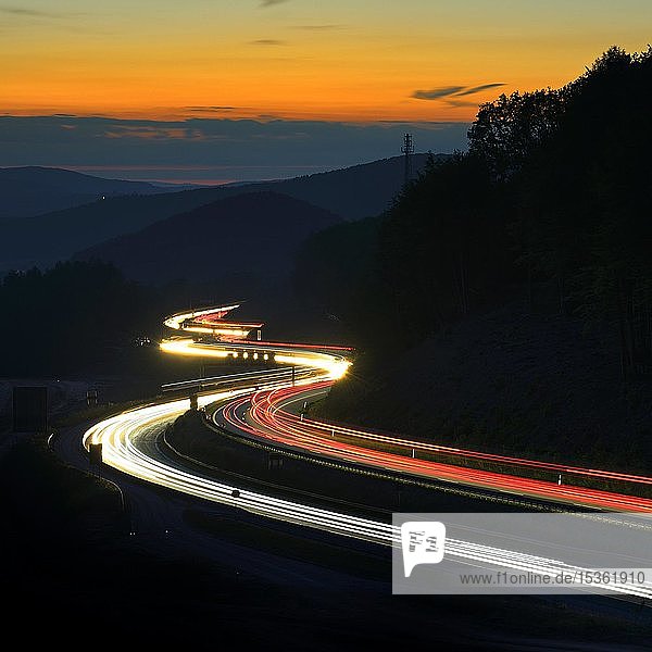 Autobahn A3 schlängelt sich durch Mittelgebirgslandschaft  Lichtspuren in der Abenddämmerung  Spessart  Bayern  Deutschland  Europa