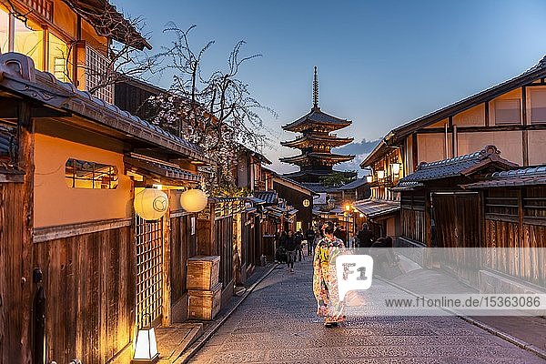 Woman in kimono in a lane  Yasaka dori historical alleyway in the old town with traditional Japanese houses  behind five-storey Yasaka pagoda of the Buddhist H?kanji temple  evening mood  Kyoto  Japan  Asia