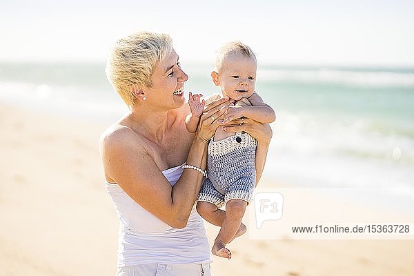 Attraktive blonde Mutter mit 4 Monate altem Babyjungen am Strand  Portugal  Europa