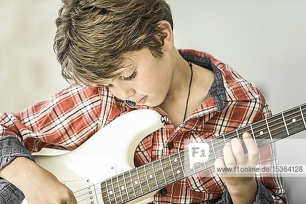 10-jähriger Junge spielt konzentriert E-Gitarre  Deutschland  Europa