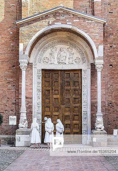 Nuns contemplate the Porta Santa of the Abbey Church of San Silvestro  Romanesque  Nonantola  Province of Modena  Emilia-Romagna  Italy  Europe