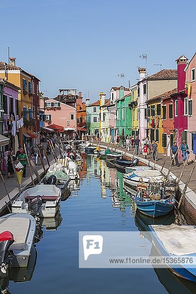 Festgemachte Boote am Kanal mit bunten Häusern  Geschäften und Touristen  Insel Burano  Venezianische Lagune  Venedig  Venetien  Italien  Europa