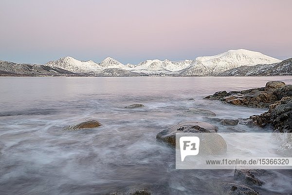 Küste im Abendlicht und Schnee bedeckte Berge Sommaroy Tromsö Norwegen Europa