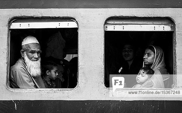 Fahrgäste mit Blick aus einem Zugfenster  Monochrom  Dhaka  Bangladesch  Asien