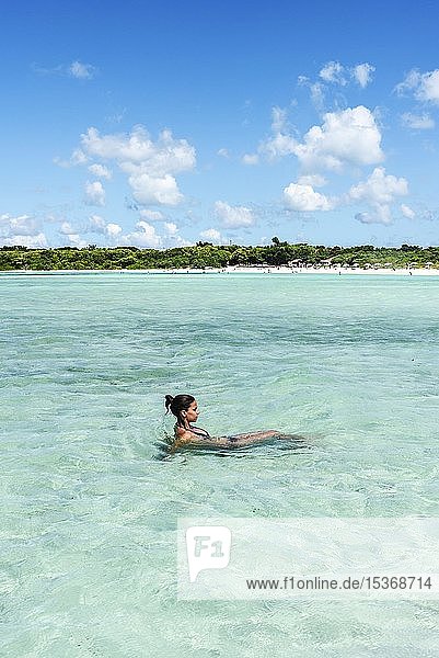 Junge Frau beim Entspannen im klaren Wasser  Kondoi-Strand  Insel Taketomi  Präfektur Okinawa  Japan  Asien