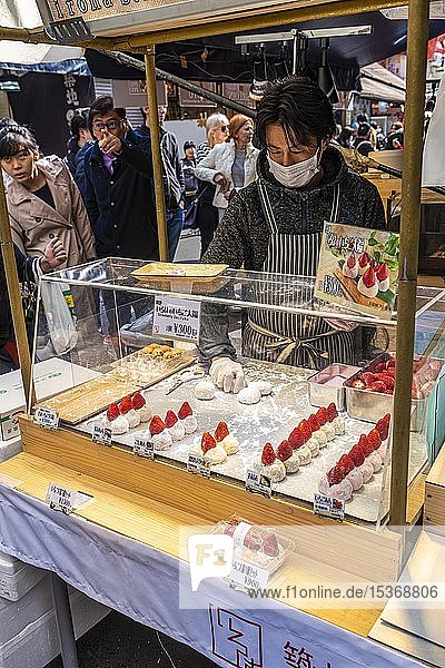 Man sells Daifuku  Japanese candy  rice cake with strawberries on a market  Tokyo  Japan  Asia