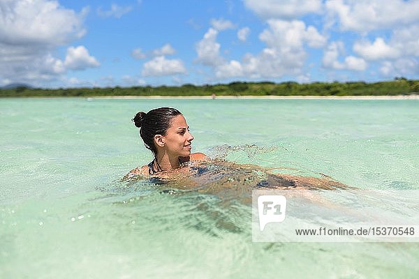 Junge Frau beim Schwimmen im Wasser  Strand Kondoi  Insel Taketomi  Präfektur Okinawa  Japan  Asien