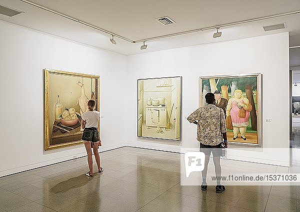 Museum visitors looking at paintings by Fernando Botero Museum of Antioquia interior Medellin Antioquia Department Colombia South America