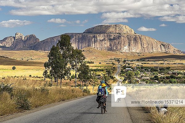 Einheimische Radfahrer auf Straße Route Nationale 7 RN7 vor Berg Bonnet de l'Eveque Bischofshut Bishop's Cap Ambavalao Ihosy district Madagaskar Afrika