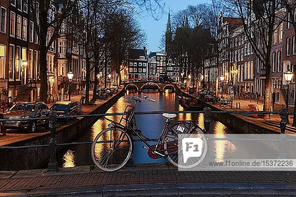Abendstimmung  Fahrrad auf einer Brücke  Leidsegracht  Gracht mit historischen Häusern  Amsterdam  Nordholland  Niederlande