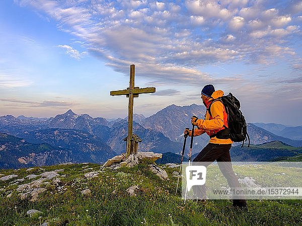 Bergsteiger am Gipfelkreuz des Hochsäul  im Hintergrund der Watzmann (rechts) und Großer Hundstod (links)  Berchtesgadener Alpen  Nationalpark Berchtesgaden  Oberbayern  Bayern  Deutschland  Europa