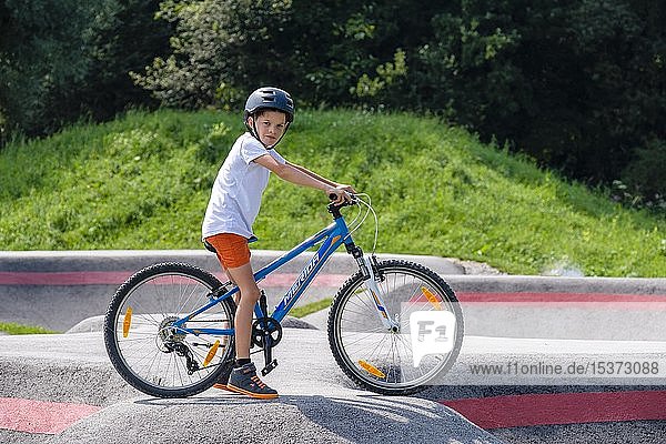 Kind  Junge  9 Jahre mit dem Mountainbike in einem Pumptrack  Mountainbike-Strecke  Viehhausen  Salzburg  Österreich  Europa