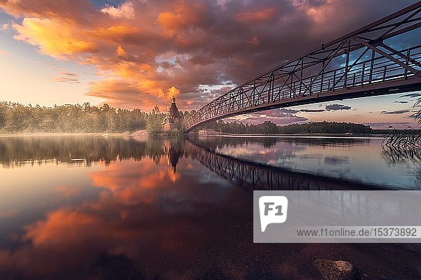Brücke und Kirche St. Andreas am Fluss Vuoksi bei Sonnenuntergang  Wassiljewo  Leningrader Gebiet  Russland  Europa