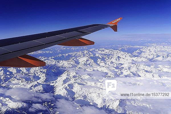 Tragfläche eines Airbus A319 der Fluggesellschaft easyJet über den schneebedeckten Alpen  Österreich  Europa