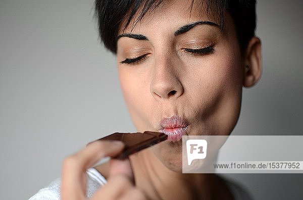 Junge Frau isst Schokolade  Porträt  Spanien  Europa