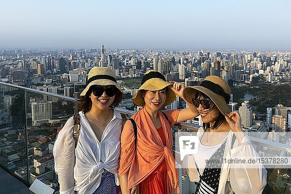 Drei junge chinesische Touristen mit Hüten auf der Aussichtsplattform des Maha Nakhon Tower  Stadtansicht  Bezirk Bang Rak  Bangkok  Thailand  Asien