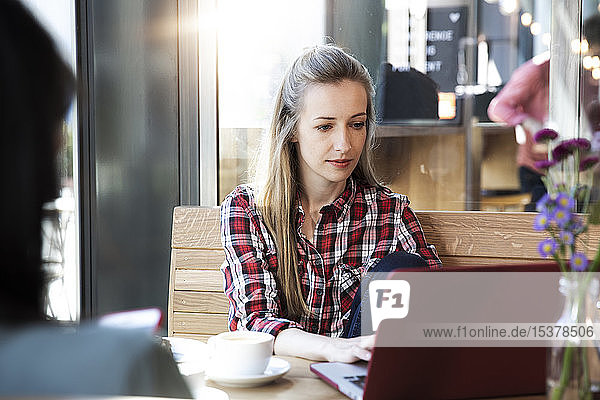 Frau benutzt Laptop in einem Café