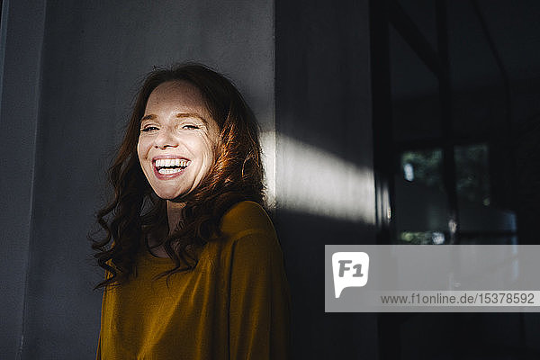 Porträt einer lachenden rothaarigen Frau mit Licht und Schatten