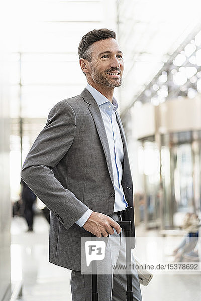 Porträt eines lächelnden Geschäftsmannes mit Gepäck