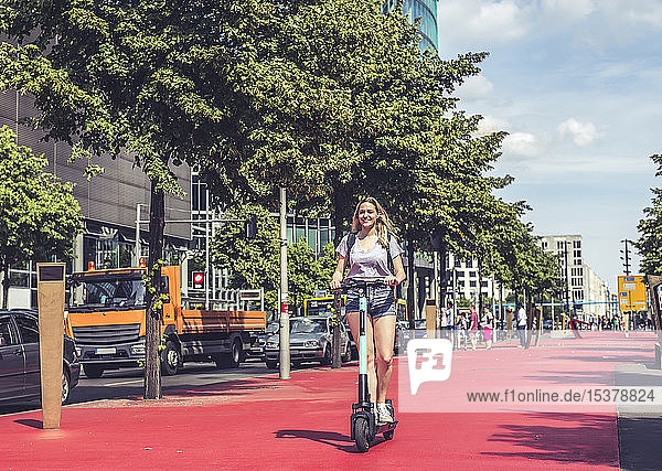 Junge Frau fährt E-Scooter auf dem Boulevard of the Stars  Berlin  Deutschland