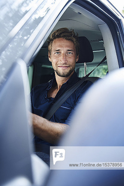 Portrait of confident young man in car