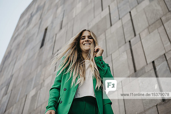 Porträt einer lachenden jungen Frau im grünen Hosenanzug  Wien  Österreich