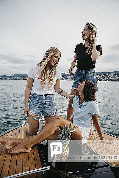 Glückliche Freundinnen haben Spaß bei einer Bootsfahrt auf einem See
