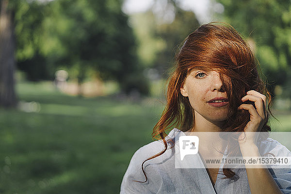 Porträt einer schönen rothaarigen Frau in einem Park