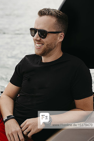 Happy man wearing sunglasses on a boat trip on a lake