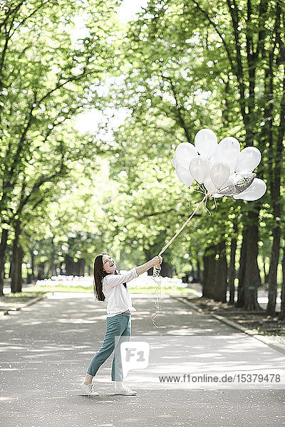 Glückliche Frau mit Luftballons in einem Park