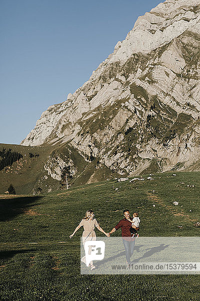 Happy family with little son on a hiking trip running on alpine meadow  Schwaegalp  Nesslau  Switzerland