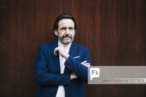 Portrait of mature businessman in front of corten wall