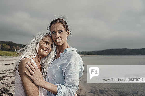 Mutter und Tochter verbringen einen Tag am Meer  umarmen sich am Strand