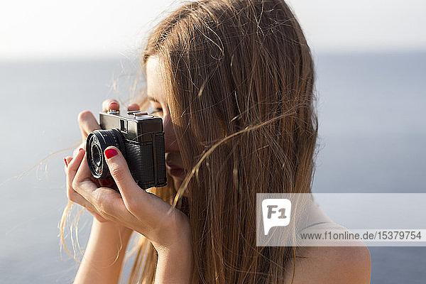 Close up of a female teenager taking a photo outdoors