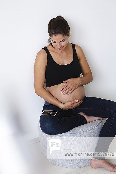Junge schwangere Frau mit Ultraschallbild ihres ungeborenen Babys