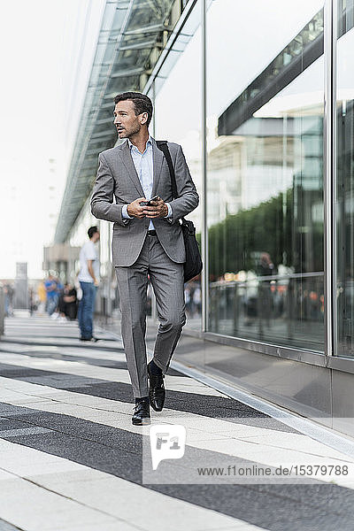 Portrait of businessman with cell phone on the go