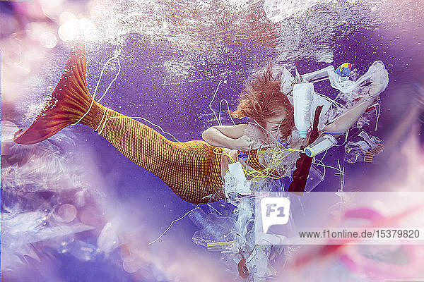 Verliebte jugendliche Meerjungfrau in Plastikmüll unter Wasser gefangen