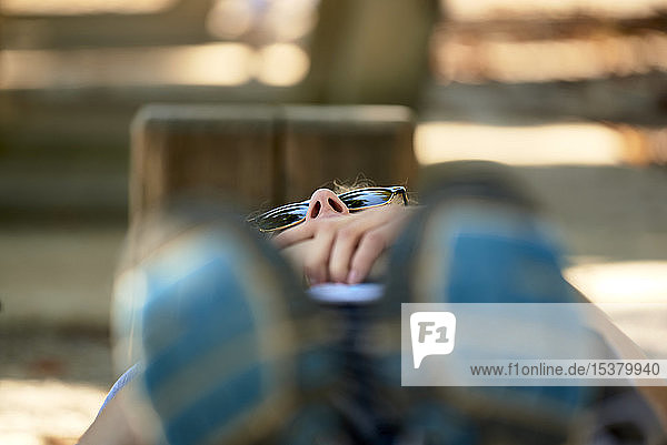 Young woman lying on park bench