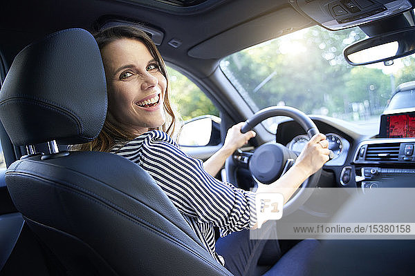 Happy woman driving car