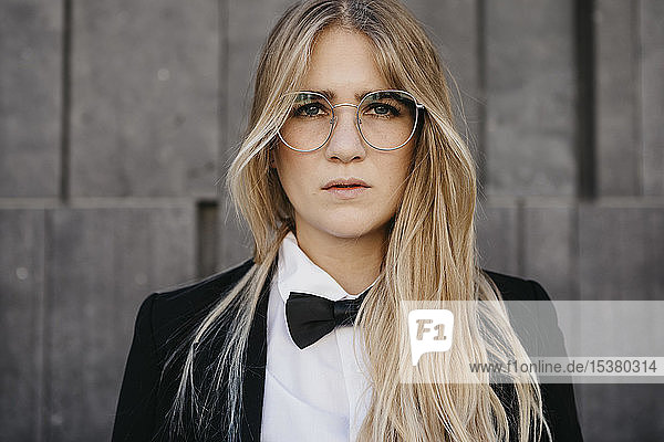 Portrait of blond young woman wearing black tie and blazer  Vienna  Austria